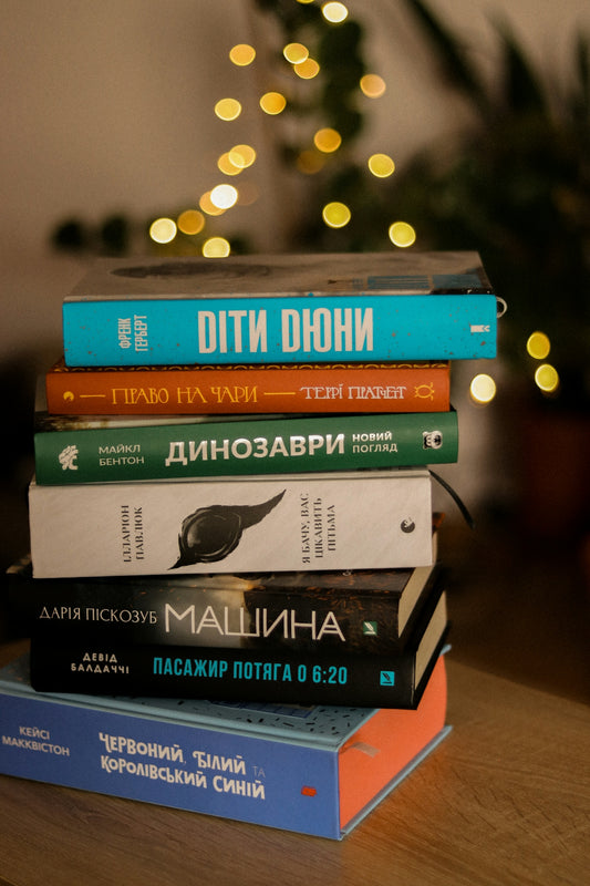 A stack of books sitting on top of a wooden table